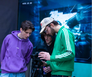 Trois étudiants de l'atelier en train de regarder le retour de la caméra.