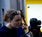 Une image représentant une étudiante de l'atelier en train de filmer une scène.