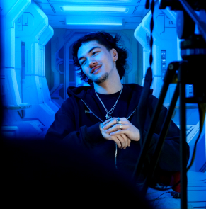 Un étudiant en train de se faire filmer avec en fond l'intérieur d'une navette spatiale.