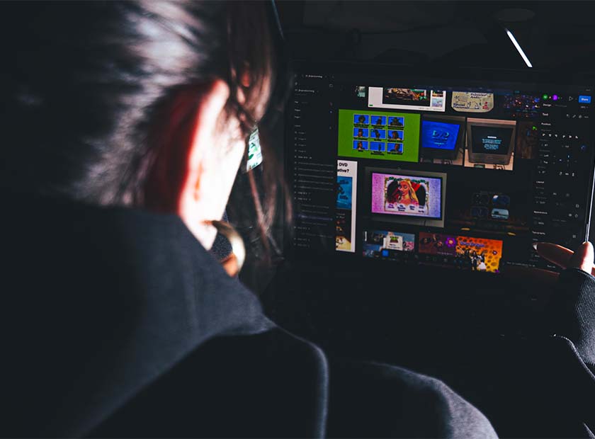 vue de dos d’une étudiante en train de travailler sur son ordinateur