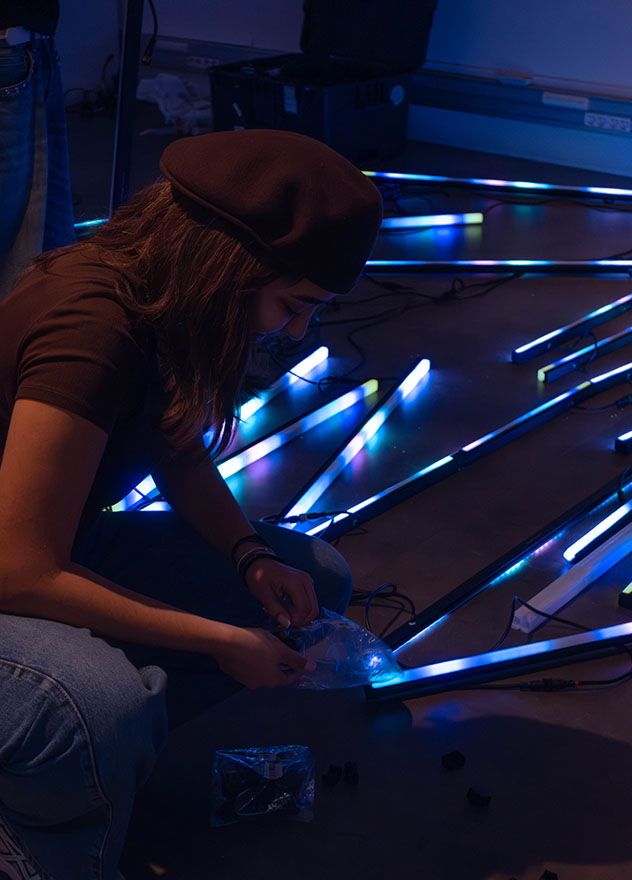 étudiante accroupie en train de mettre en place des leds