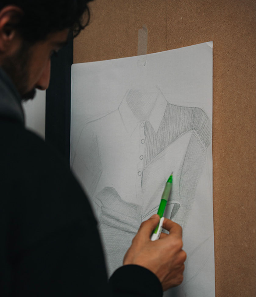 Vue d’un étudiant debout en train de dessiner une chemise.