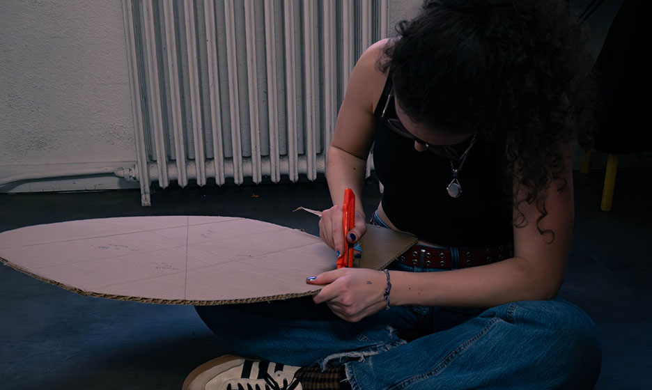 Vue sur une étudiante qui découpe un cercle en carton.