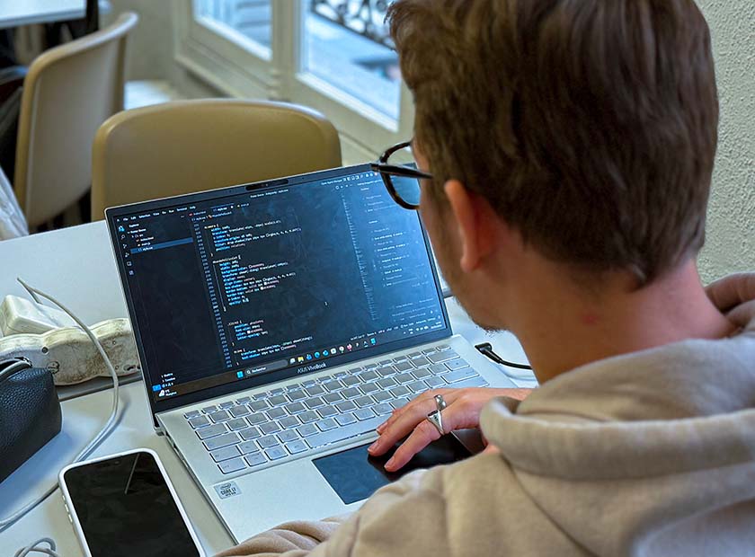 vue de dos d’un étudiant en train de coder