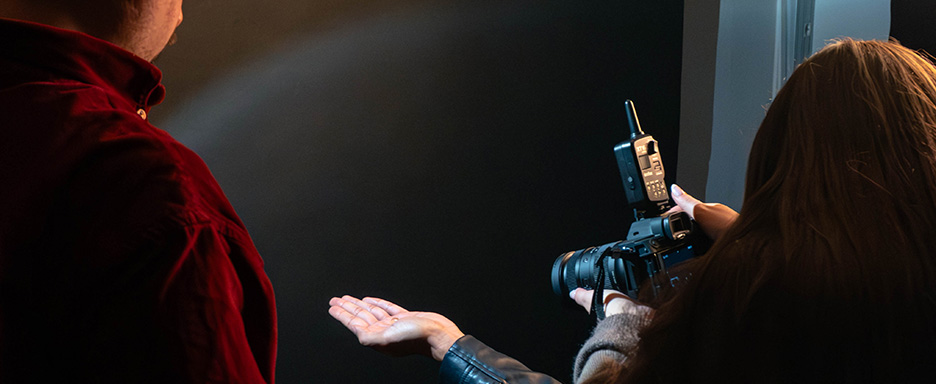 Vue de dos d’une étudiante mettant sa main en lumière avec des projecteurs